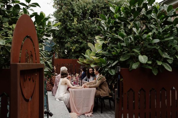 wedding guests sitting at an outdoor table at miss midgleys apartments