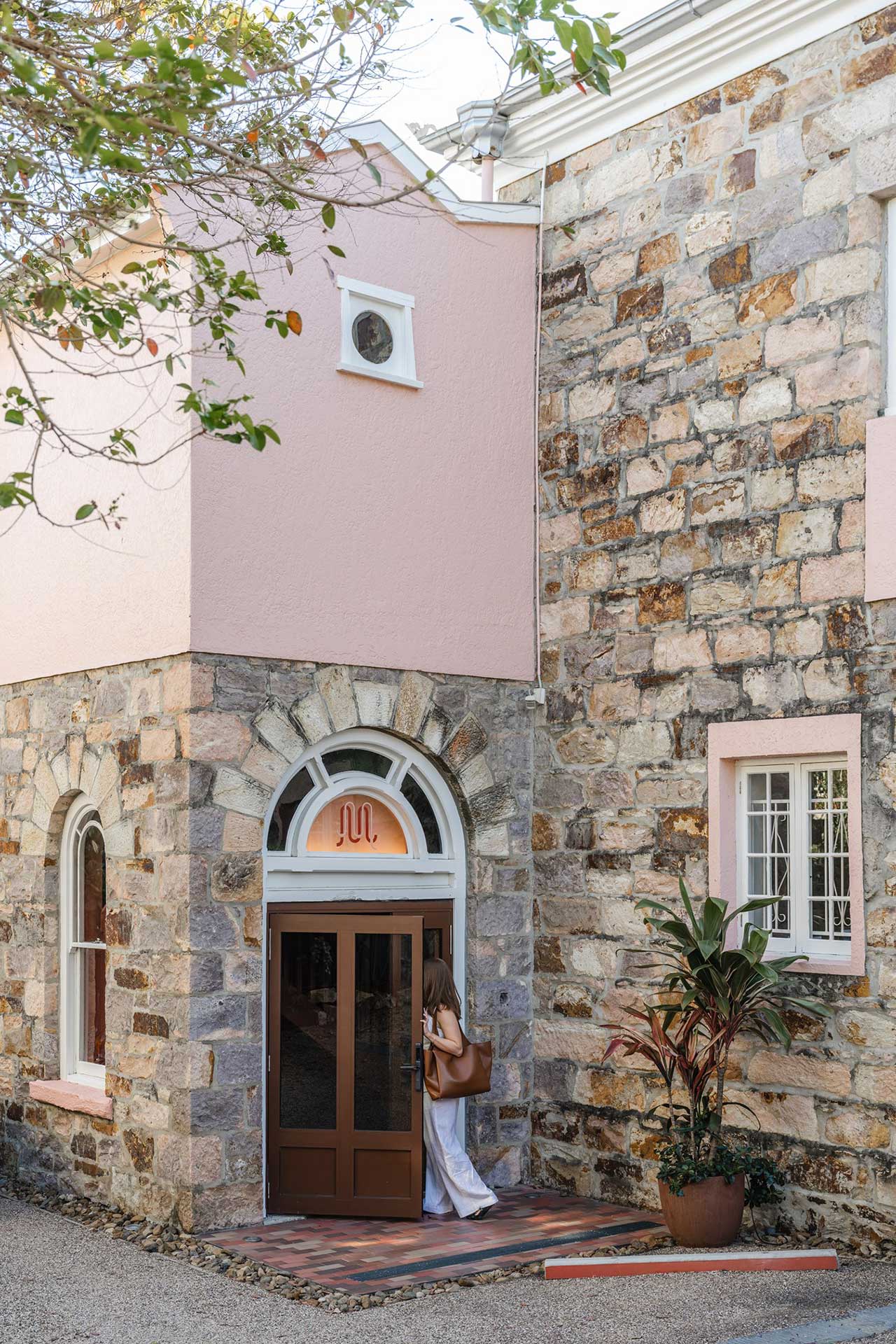 woman walking in the front door of a boutique heritage listed building in brisbane called miss midgelys